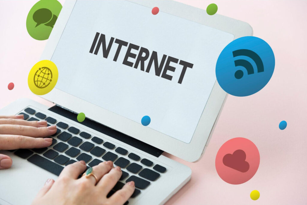 Person typing on a laptop with the word “internet” on the screen with animated icons hovering above.