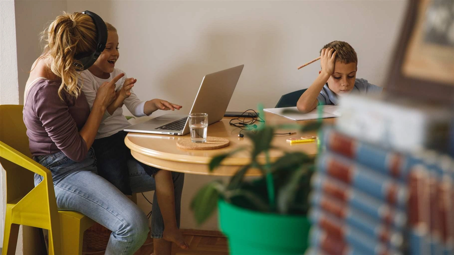 A mother helps her child with online learning.