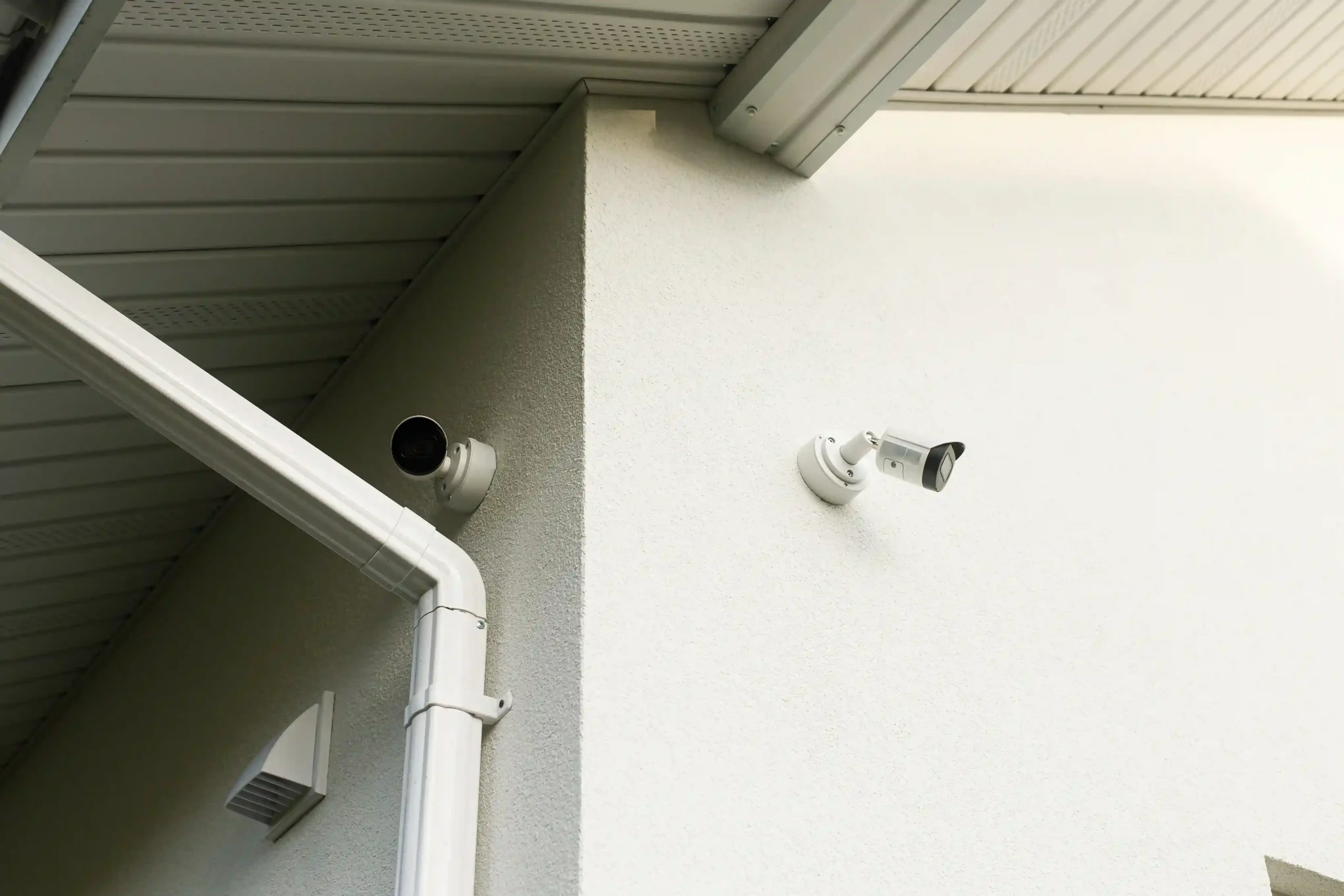 Two security cameras mounted on a wall.