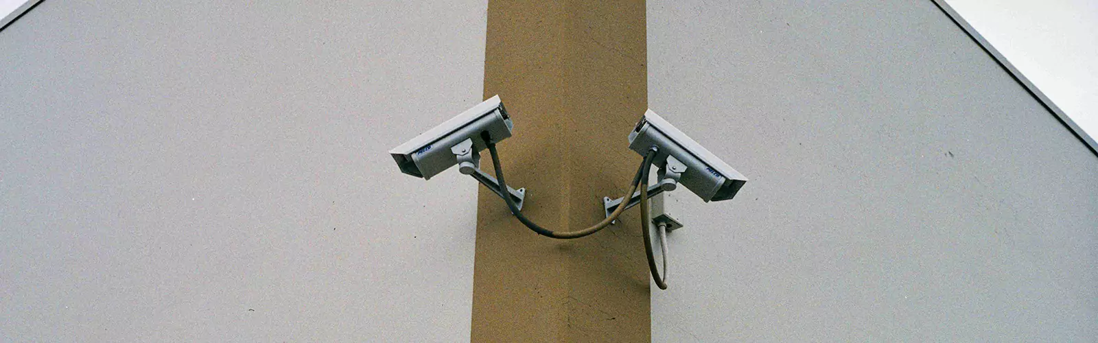 Two surveillance cameras mounted on a wall.