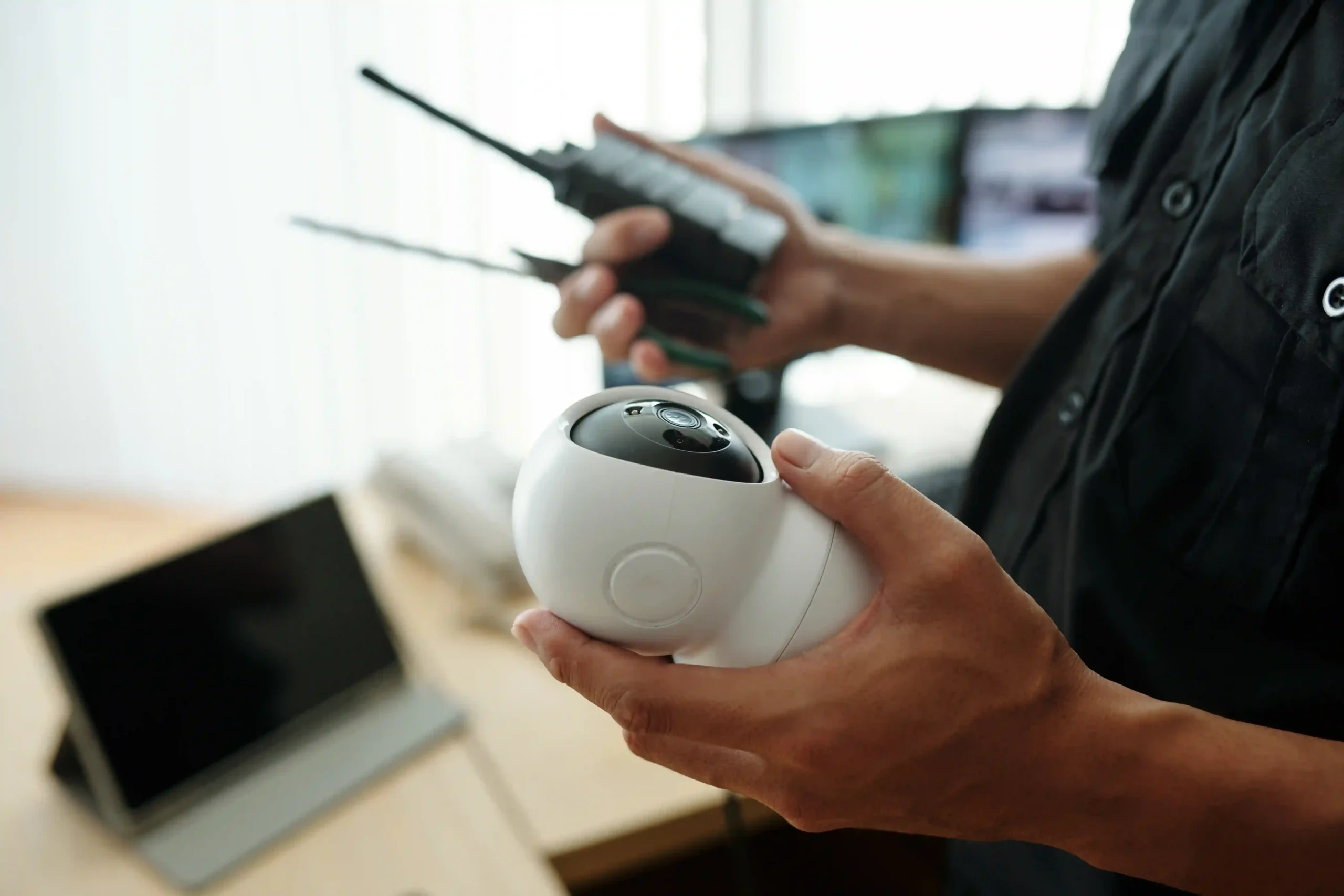 Person holding a security camera and remote.