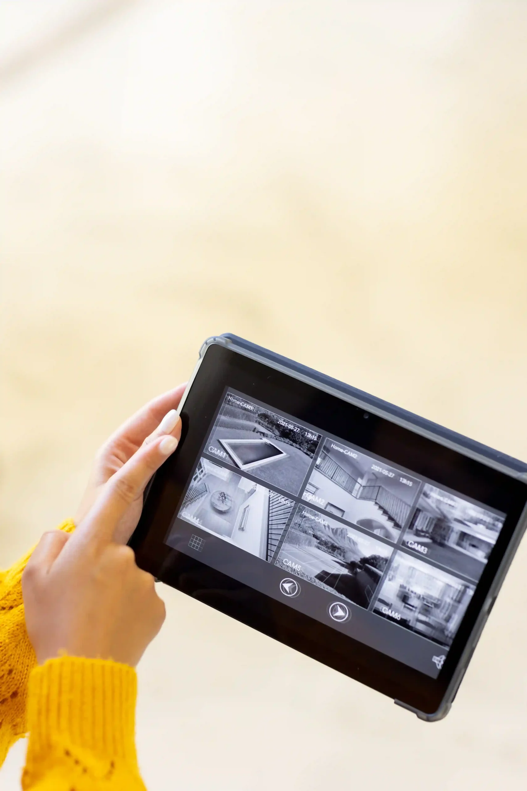 Person using a tablet to monitor security cameras.