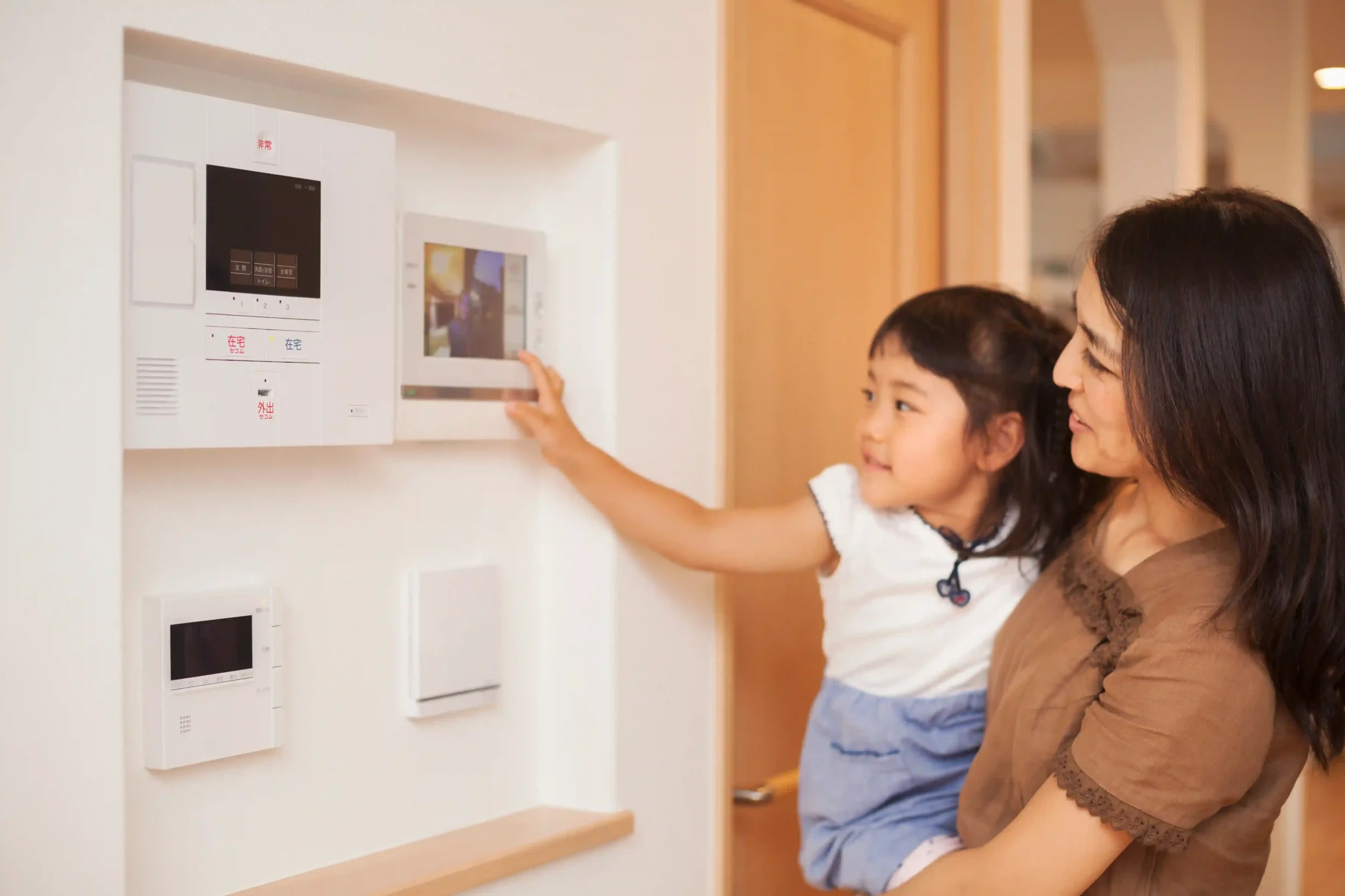 A mother and daughter interacting with a smart device.