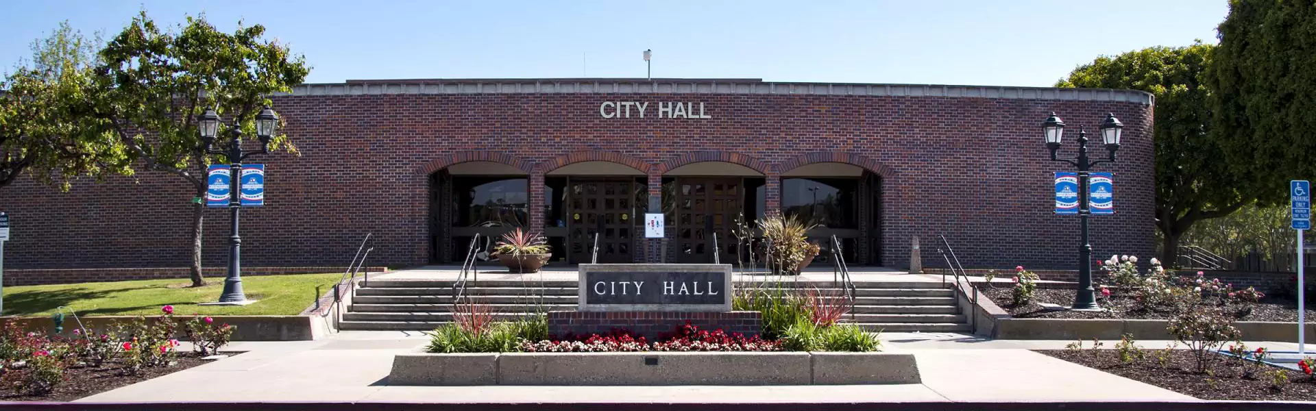 Exterior view of City Hall building with landscaping.