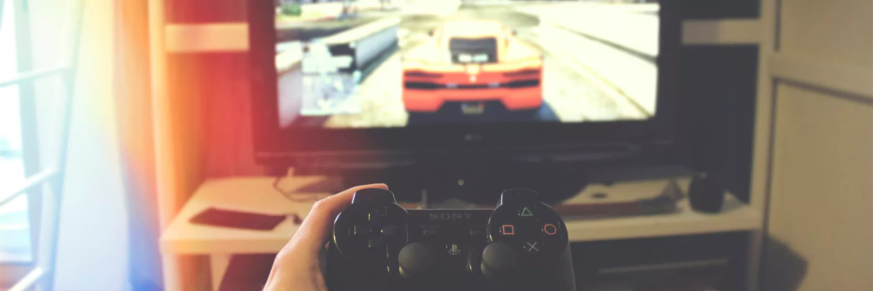 Person playing video game with gaming controller.