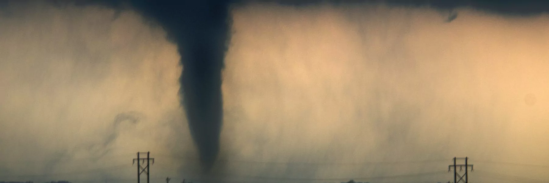 Tornado forming against a cloudy sky.