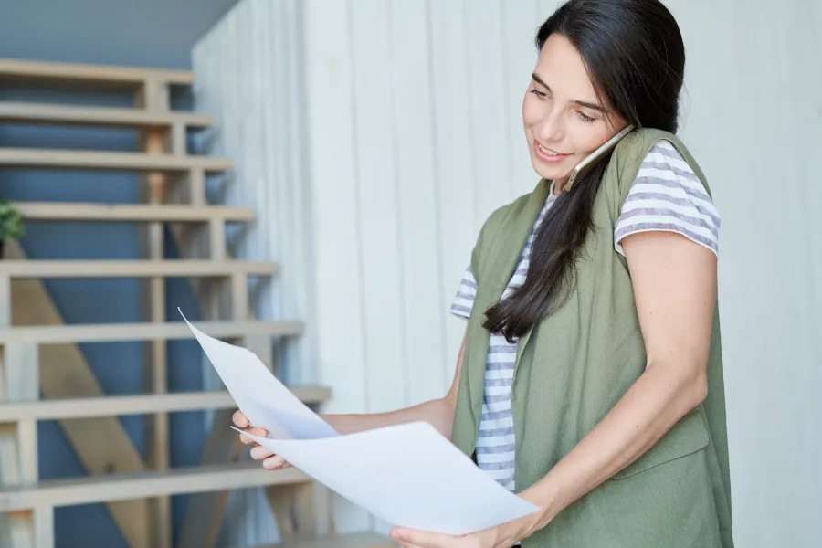Woman talking on phone while reviewing documents.