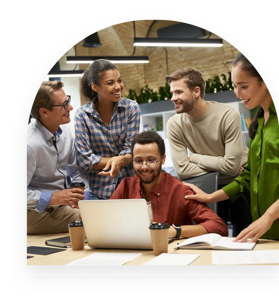 Group collaborating around a laptop in an office.