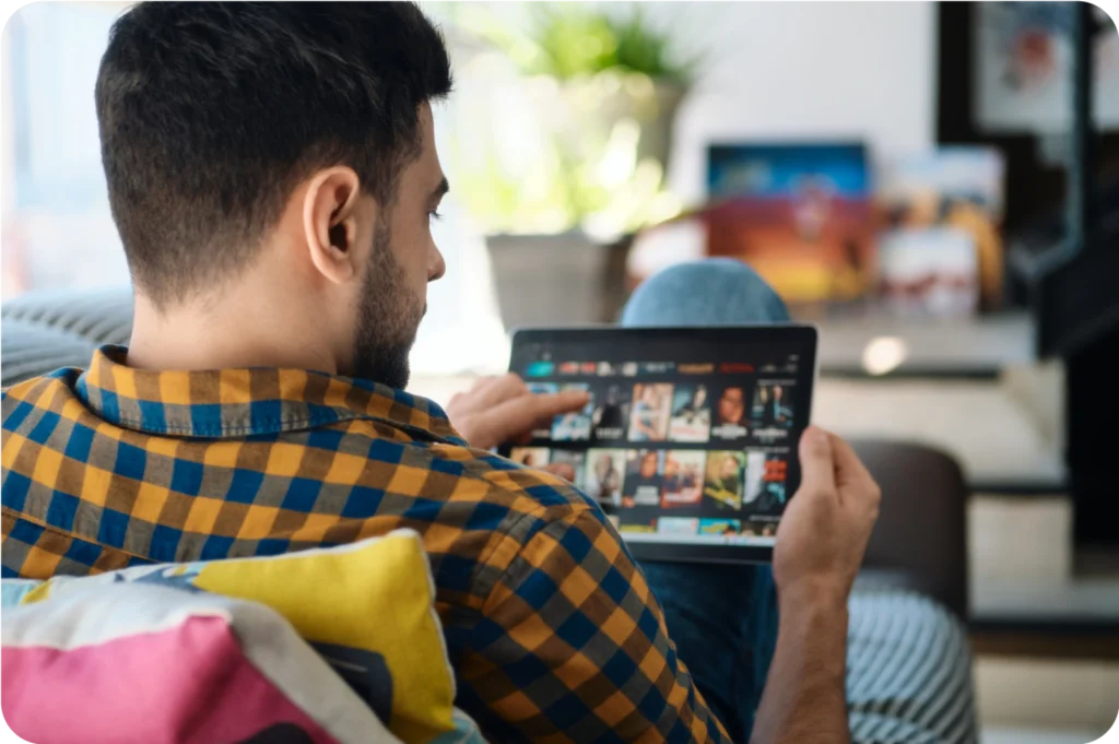 Man browsing streaming options on a tablet.