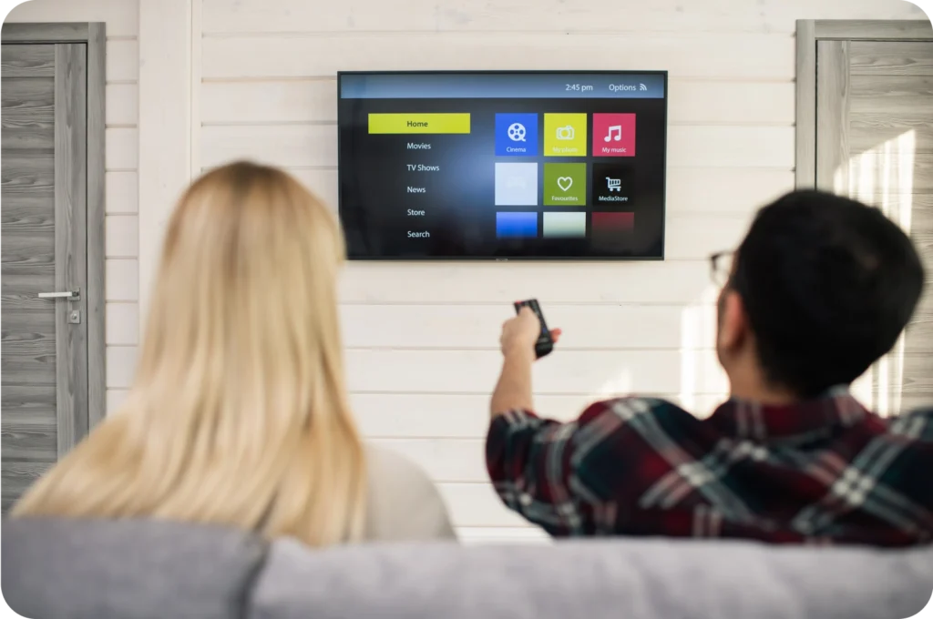 Couple using a smart TV interface at home.