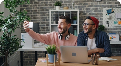 Two friends taking a selfie in an office.