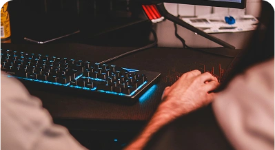Person typing on a backlit gaming keyboard